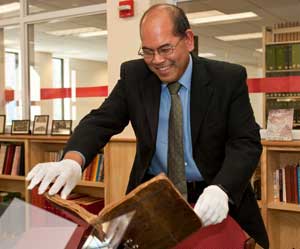 KSC Archivist Rodney Obien demonstrates one of the Archives & Special Collections' reading stands. Photo by Al Karevy