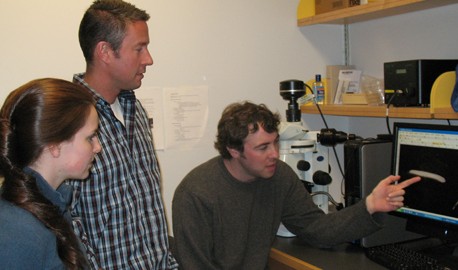 Brad Stubenhaus (at the computer) points out some of his findings on planarians to Emily Neverett and Dr. Pellettieri.